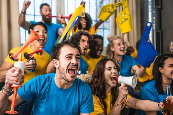 Multiracial joyful sport fans watching game on TV at home - Supporters having fun on sofa for competition event on TV - Friends celebrating victory when sport team wins worlds championship