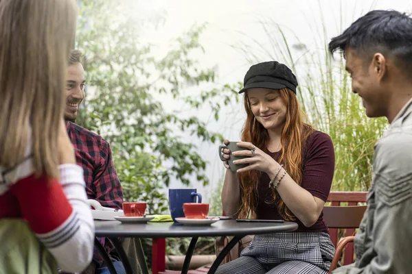 人们在咖啡吧花园一起喝拿铁咖啡 快乐的朋友在宾馆里聊天和玩乐 在露天咖啡馆里与快乐的男人和女孩一起生活方式的概念 温暖生动的过滤器 — 图库照片