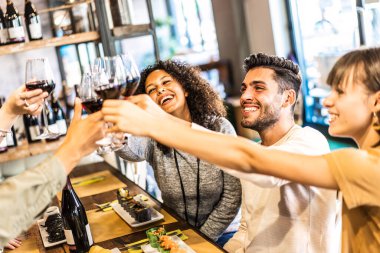 Suşi restoranında kırmızı şarap içen çok ırklı arkadaşlar - Füzyon barında birlikte eğlenen mutlu insanlarla yiyecek ve içecek yaşam tarzı konsepti - Sağdaki adama odaklı sıcak, parlak filtre