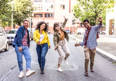 Şehir merkezinde gezen çok ırklı ve modaya uygun arkadaşlar eğlenceli çılgın hareketler yapıyorlar - genç kolej öğrencileri ve kızların şehir sokaklarında eğlendiği havalı yaşam tarzı konsepti - parlak canlı filtre