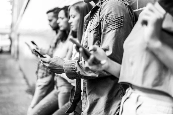 Üniversitenin arka bahçesinde akıllı telefon kullanan sıkılmış arkadaşlar grubu cep telefonu bağımlısı gençler her zaman bağlı öğrencilerle birlikte teknoloji üzgün yaşam konsepti