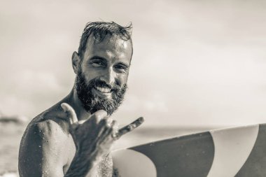 Sörf yaparken gülümseyen sörfçülerle mutlu olan sörfçü, sörf yaparken Hawaii Shaka Brah ya da Hang Loose sörf yaparken okyanus dalgalarında sahil tatilinde - sörfçü kültüründe dostça karşılama - siyah ve beyaz kurgu