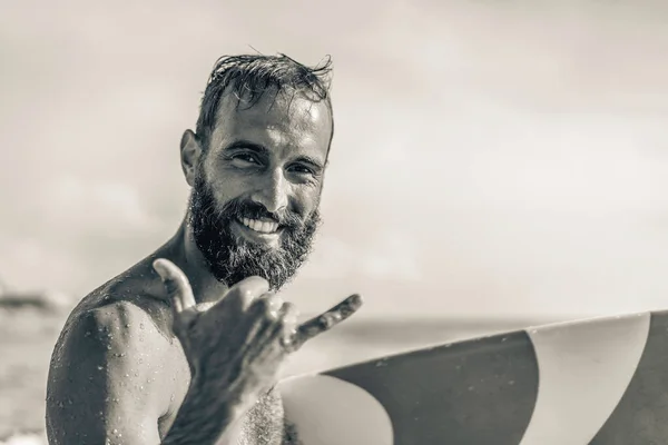 サーフィンの笑顔でサーフィンを楽しむハワイのシャカブラフやハンローズビーチ休暇中の海の波でのサーフィンセッション中に サーファー文化のフレンドリーな挨拶 黒と白の編集 ロイヤリティフリーのストック画像