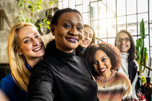 フードオフィスのカメラに笑顔を浮かべながら自撮りをする多民族女性友達楽しい多文化女性たち前景に黒人女性の顔を中心とした明るいフィルター — ストック写真