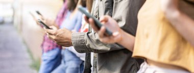 Üniversitenin arka bahçesinde oturan akıllı telefonları kullanan sıkıcı arkadaş grubuyla yatay afiş cep telefonu bağımlısı gençler her zaman bağlı öğrencilerle teknoloji üzgün yaşam konsepti