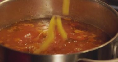 Adding pasta to the soup. Slow motion video of boiling soup. High quality 4k footage