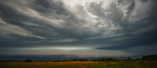 Supercell cloud with distant lightning illuminating the storm structure. Climate change concept