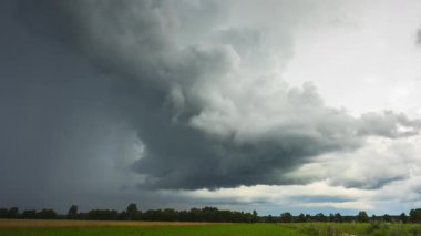 Litvanya 'daki tarlalarda hızla ilerleyen süper hücre fırtınası, kara fırtına bulutları....