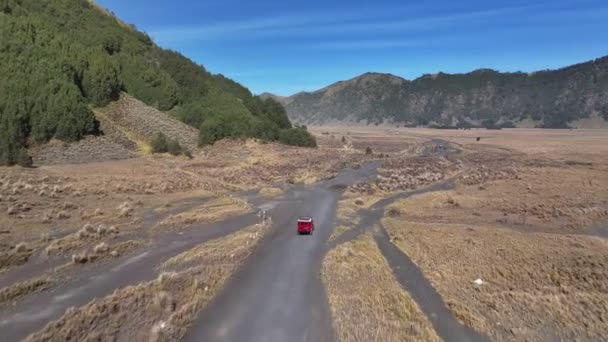 从空中观察无人驾驶飞机跟踪一辆汽车前往印度尼西亚布罗莫火山 — 图库视频影像