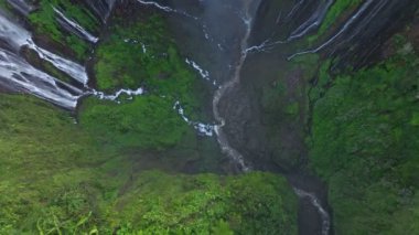 Hava manzarası ağaçların üzerinden uçar ve Tumpak Sewu şelalesini, Endonezya 'yı gözler önüne serer.