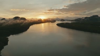 Tayland 'ın Phang nga eyaletinde gün doğumuyla birlikte geriye doğru uçan hava aracı.