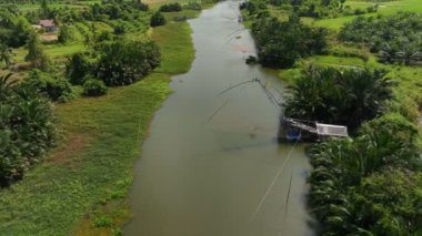 Hava aracı geri uçar ve Pak Pra Köyü, Phatthalung, Tayland 'da bulunan geleneksel kanal ve balık avlama tuzağını ortaya çıkarır.