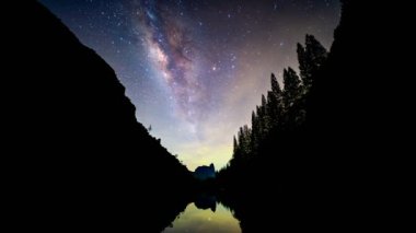Timelapse of milky way and star with silhouette valley and reflection at lake of Phang Nga, Thailand