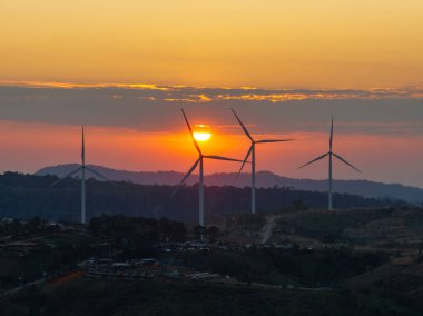 Gün batımında drone siluet rüzgar türbinleri çiftliğinden hava görüntüsü