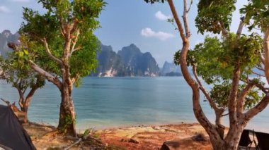 Hava aracı ağaçların arasından uçarak Khao Sok Ulusal Parkı, Suratthani, Tayland gölü arasındaki dağın zirvesini ortaya çıkardı.