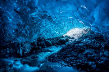 Vatnajokull buzulu içinde yer altı nehri olan kristal mavisi bir buz mağarasının girişi, İzlanda