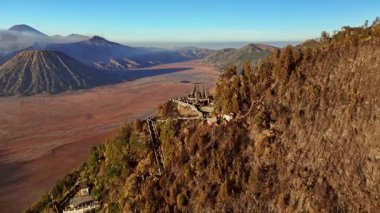 Bromo volkanı, Java ve Endonezya 'yı ortaya çıkarmak için hava manzarası turist kalabalığı üzerinde yörüngede uçuyor.