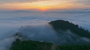 Güneş doğarken sis denizi üzerinde uçan yüksek hızda uçan hava aracı.