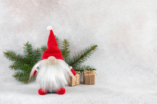 stock image Xmas dwarf in red hat with fir branch holiday card on light winter background. Nordic gnome greeting card with copy space