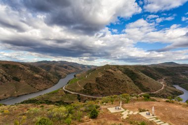 The Douro valley with its river and its vineyards cultivated in terraces on the mountainsides. Superb cloudy sky reflected in the waters of the river. North Region, Portugal. Light and natural colors.