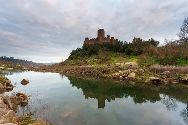 Almourol Kalesi 'nde gün batımı, Portekiz' de Tagus Nehri. Gün batımında, kırmızı bulutların altındaki kale duvarlarıyla muhteşem bir manzara. Güzel Landmark bir tatil beldesidir..