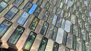 Glass wall of Harpa concert hall, Reykjavik, Iceland. Colorful glass windows with abstract geometry. Modern art at amazing travel destination and tourist attraction in the Nordic country.