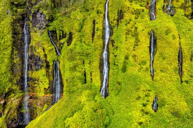 Azores scenic aerial drone landscape, Flores island. Iconic lagoon with several waterfalls on a single rockface, flowing into lake Alagoinha. Best travel destination in Portugal. clipart