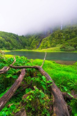 Azores scenic landscape, Flores island. Iconic lagoon with several waterfalls on a single rockface, flowing into lake Alagoinha. Best travel destination in Portugal, amazing vacations place. clipart