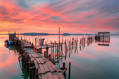 Carrasqueira, Alentejo, Portekiz 'in saray iskelesinde muhteşem bir gün batımı. Sado Nehri 'nde geleneksel tekneleri olan ahşap balıkçı limanı. ince sanatsal renk yatay fotoğrafçılık.