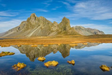 İzlanda kıyılarının muhteşem manzarası. Güney İzlanda 'da çevre yolu, dağlar ve çarpıcı manzaralı. Turistik eğlence ve seyahat yeri.