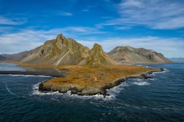 İzlanda kıyılarının muhteşem manzarası. Güney İzlanda 'da çevre yolu, dağlar ve çarpıcı manzaralı. Turistik eğlence ve seyahat yeri.