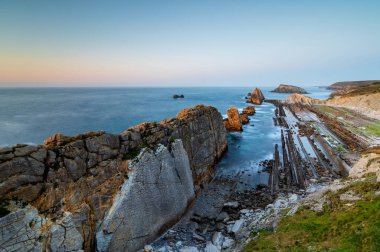 Playa de la Arnia 'nın dramatik manzarası, Cantabria, İspanya. Arnia Plajı, gün batımında Asturias. İnanılmaz manzara, çizgiler, soyut şekiller güzel renkler..