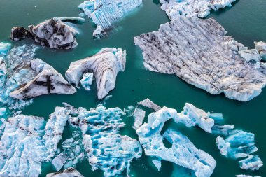 Jokulsarlon Buzul Gölü, İzlanda, gün batımında. Güzel buz blokları ve bazı foklar dağdan gelen soğuk suyun içinden akar. İzlanda ve Avrupa 'nın en büyük buzulunun manzarası