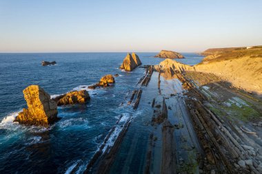Playa de la Arnia 'nın dramatik manzarası, Cantabria, İspanya. Arnia Plajı, gün batımında Asturias. İnanılmaz manzara, çizgiler, soyut şekiller güzel renkler..