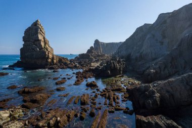 Playa de la Arnia 'nın dramatik manzarası, Cantabria, İspanya. Arnia Plajı, gün batımında Asturias. İnanılmaz manzara, çizgiler, soyut şekiller güzel renkler..