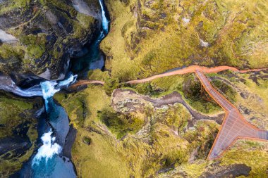 Spectacular view into fjadrargljufur canyon in southern Iceland, landscape of a river going through an emerald canyon in the Iceland wilderness. clipart