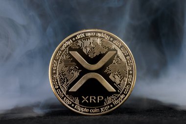 XRP dalgalanması. Kripto para birimi. Duman efektli altın para.