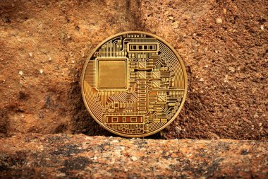 Golden cryptocurrency coin with circuit details placed on a textured brick background. clipart