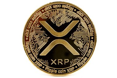 Dijital para birimini temsil eden beyaz arkaplandaki dalgalı XRP madeni parasının yakın plan görüntüsü.