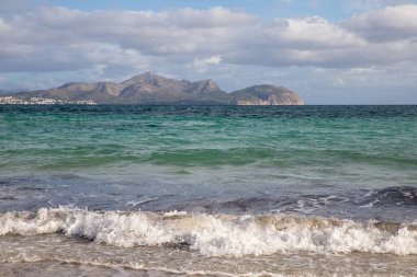 Mayorka adasındaki Akdeniz plajı veya Mallorca, İspanya 'nın bir parçası olan ve Akdeniz' de bulunan Balear Adaları 'nın en büyük plajıdır. Deniz kenarında tatiller, bulutlar, deniz manzarası. Deniz ve ada manzarası.  