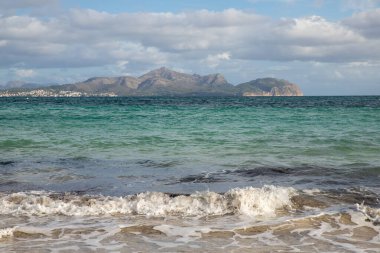 Mayorka adasındaki Akdeniz plajı veya Mallorca, İspanya 'nın bir parçası olan ve Akdeniz' de bulunan Balear Adaları 'nın en büyük plajıdır. Deniz kenarında tatiller, bulutlar, deniz manzarası. Deniz ve ada manzarası.  