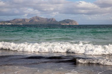 Mayorka adasındaki Akdeniz plajı veya Mallorca, İspanya 'nın bir parçası olan ve Akdeniz' de bulunan Balear Adaları 'nın en büyük plajıdır. Deniz kenarında tatiller, bulutlar, deniz manzarası. Deniz ve ada manzarası.  