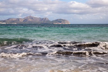 Mayorka adasındaki Akdeniz plajı veya Mallorca, İspanya 'nın bir parçası olan ve Akdeniz' de bulunan Balear Adaları 'nın en büyük plajıdır. Deniz kenarında tatiller, bulutlar, deniz manzarası. Deniz ve ada manzarası.  