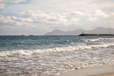 Mayorka adasındaki Akdeniz plajı veya Mallorca, İspanya 'nın bir parçası olan ve Akdeniz' de bulunan Balear Adaları 'nın en büyük plajıdır. Deniz kenarında tatiller, bulutlar, deniz manzarası. Deniz ve ada manzarası.  