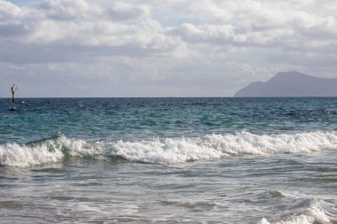 Mayorka adasındaki Akdeniz plajı veya Mallorca, İspanya 'nın bir parçası olan ve Akdeniz' de bulunan Balear Adaları 'nın en büyük plajıdır. Deniz kenarında tatiller, bulutlar, deniz manzarası. Deniz ve ada manzarası.  