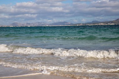 Mayorka adasındaki Akdeniz plajı veya Mallorca, İspanya 'nın bir parçası olan ve Akdeniz' de bulunan Balear Adaları 'nın en büyük plajıdır. Deniz kenarında tatiller, bulutlar, deniz manzarası. Deniz ve ada manzarası.  