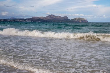 Mayorka adasındaki Akdeniz plajı veya Mallorca, İspanya 'nın bir parçası olan ve Akdeniz' de bulunan Balear Adaları 'nın en büyük plajıdır. Deniz kenarında tatiller, bulutlar, deniz manzarası. Deniz ve ada manzarası.  