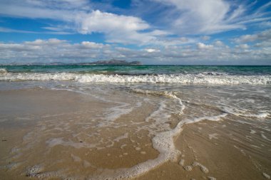 Mayorka adasındaki Akdeniz plajı veya Mallorca, İspanya 'nın bir parçası olan ve Akdeniz' de bulunan Balear Adaları 'nın en büyük plajıdır. Deniz kenarında tatiller, bulutlar, deniz manzarası. Deniz ve ada manzarası.  