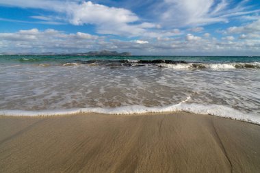 Mayorka adasındaki Akdeniz plajı veya Mallorca, İspanya 'nın bir parçası olan ve Akdeniz' de bulunan Balear Adaları 'nın en büyük plajıdır. Deniz kenarında tatiller, bulutlar, deniz manzarası. Deniz ve ada manzarası.  