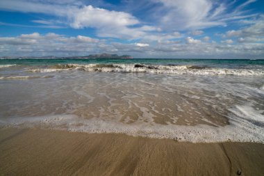 Mayorka adasındaki Akdeniz plajı veya Mallorca, İspanya 'nın bir parçası olan ve Akdeniz' de bulunan Balear Adaları 'nın en büyük plajıdır. Deniz kenarında tatiller, bulutlar, deniz manzarası. Deniz ve ada manzarası.  